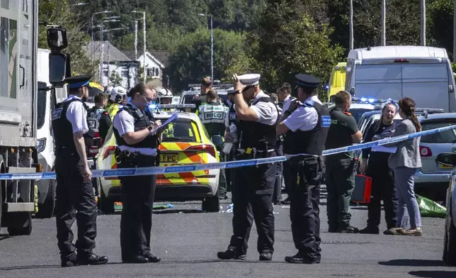 Police secure the area, where a man has been detained and a knife has been seized after a number of people were injured in a reported stabbing, in Southport, Merseyside, England, Monday July 29, 2024. (James Speakman/PA via AP)