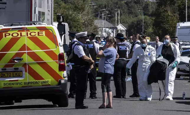 Police work at the scene in Southport, England, where a man has been detained and a knife has been seized after a number of people were injured in a reported stabbing, Monday July 29, 2024. (James Speakman/PA via AP)