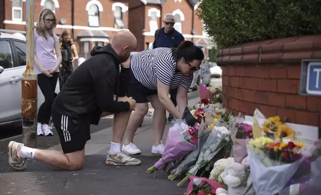 People leave flowers near the scene in Hart Street where two children died and nine were injured in a knife attack during a Taylor Swift event at a dance school on Monday, in Southport, England, Tuesday, July 30, 2024. Taylor Swift says she is “completely in shock” after two children died in a stabbing attack in a dance and yoga class themed on the singer. (James Speakman/PA via AP)