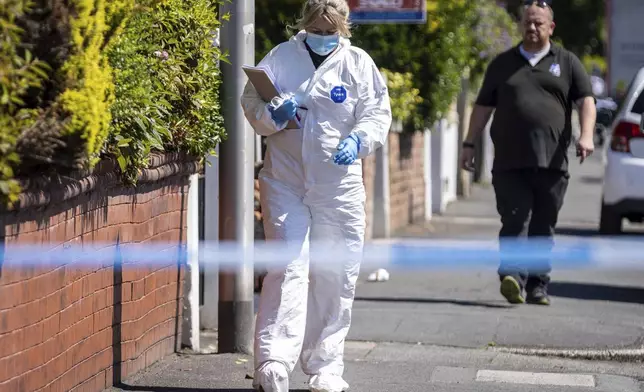 A police scenes of crime officer (SOCO) works at the scene in Southport, Merseyside, where a man has been detained and a knife has been seized after a number of people were injured in a reported stabbing, Monday July 29, 2024. (James Speakman/PA via AP)