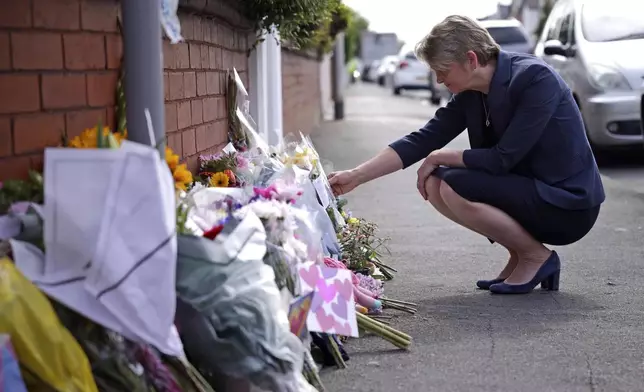 British Home Secretary Yvette Cooper looks at tributes near the scene in Hart Street where two children died and nine were injured in a knife attack during a Taylor Swift event at a dance school on Monday, in Southport, England, Tuesday, July 30, 2024. Taylor Swift says she is “completely in shock” after two children died in a stabbing attack in a dance and yoga class themed on the singer. (James Speakman/PA via AP)