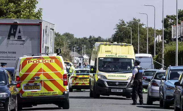 Emergency services work at the scene in Southport, England, where a man has been detained and a knife has been seized after a number of people were injured in a reported stabbing, Monday July 29, 2024. (James Speakman/PA via AP)