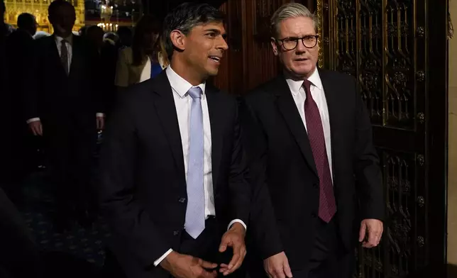 Prime Minister Keir Starmer, right, and former Prime Minister and leader of the Opposition Rishi Sunak talk as they walk from the House of Lords after listening to the King's Speech during the State Opening of Parliament in the London, Wednesday, July 17, 2024. King Charles III's speech will set out the agenda of the UK's first Labour government for 14 years. (AP Photo/Alberto Pezzali, Pool)