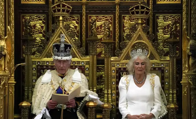 King Charles III looks up as he reads the King's Speech, as Queen Camilla sits beside him during the State Opening of Parliament in the House of Lords, London, Wednesday, July 17, 2024. King Charles III's speech will set out the agenda of the UK's first Labour government for 14 years. (AP Photo/Alberto Pezzali, Pool)