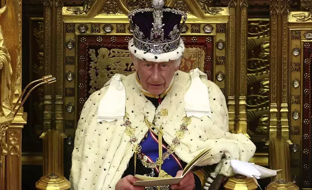 Britain's King Charles III, wearing the Imperial State Crown and the Robe of State, reads the King's Speech from the The Sovereign's Throne in the House of Lords chamber, during the State Opening of Parliament, at the Houses of Parliament, in London, Wednesday, July 17, 2024. (Henry Nicholls/Pool Photo via AP)