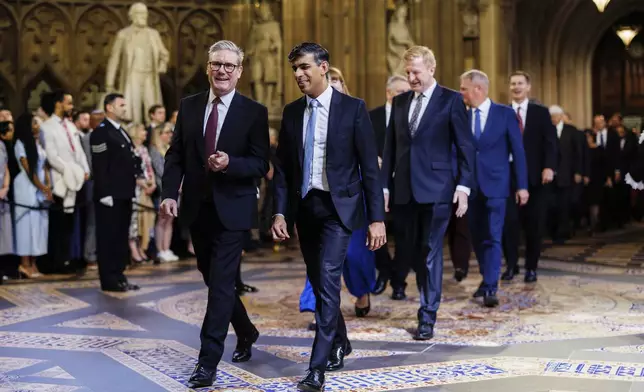 Prime Minister Sir Keir Starmer, left, and Conservative leader Rishi Sunak, right, lead MPs through the Central Lobby at the Palace of Westminster ahead of the State Opening of Parliament in London, Wednesday, July 17, 2024. (Dan Kitwood/POOL via AP)