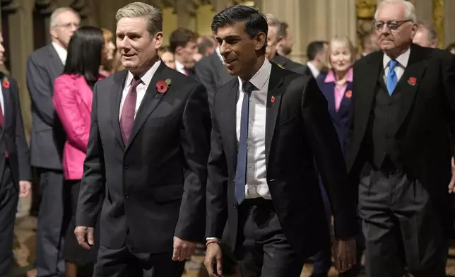 FILE - Britain's then-Prime Minister Rishi Sunk, right, and Labour Party leader Keir Starmer pass through the Peer's Lobby to attend the State Opening of Parliament, at the Palace of Westminster in London, Tuesday, Nov. 7, 2023. King Charles III will officially open the new session of Parliament on Wednesday, July 17, 2024, donning his ceremonial robes and the crown of state to deliver a speech laying out the legislative program of the U.K.’s first left-leaning government in 14 years. (AP Photo/Alastair Grant, Pool, File)