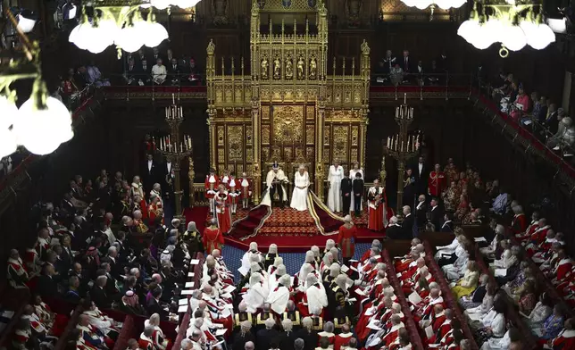 Britain's King Charles III, wearing the Imperial State Crown and the Robe of State, sits alongside Britain's Queen Camilla, wearing the George IV State Diadem, as he reads the King's Speech from the The Sovereign's Throne in the House of Lords chamber, during the State Opening of Parliament, at the Houses of Parliament, in London, Wednesday, July 17, 2024. (Henry Nicholls/POOL via AP)