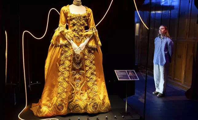 A member of staff views exhibits from previous concert tours that are displayed at the 'Taylor Swift Songbook Trail Exhibition' at the Victoria &amp; Albert Museum, on Wednesday, July 24, 2024 in London. (Photo by Scott A Garfitt/Invision/AP)