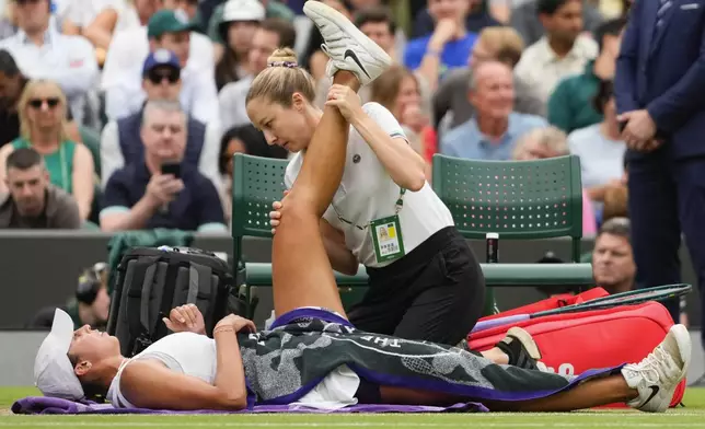 Madison Keys of the United States receives medical attention during her fourth round match against Jasmine Paolini of Italy at the Wimbledon tennis championships in London, Sunday, July 7, 2024. (AP Photo/Kirsty Wigglesworth)