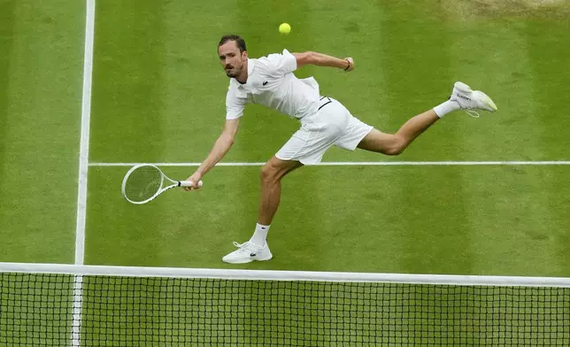 Daniil Medvedev of Russia plays a forehand return to Jannik Sinner of Italy during their quarterfinal match at the Wimbledon tennis championships in London, Tuesday, July 9, 2024. (AP Photo/Mosa'ab Elshamy)