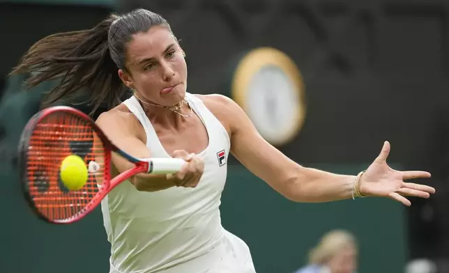 Emma Navarro of the United States plays a forehand return to Jasmine Paolini of Italy during their quarterfinal match at the Wimbledon tennis championships in London, Tuesday, July 9, 2024. (AP Photo/Alberto Pezzali)