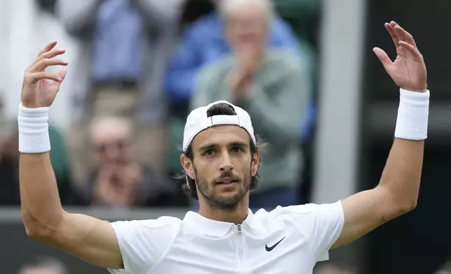 Lorenzo Musetti of Italy celebrates after defeating Giovanni Mpetshi Perricard of France in their fourth round match at the Wimbledon tennis championships in London, Monday, July 8, 2024. (AP Photo/Mosa'ab Elshamy)