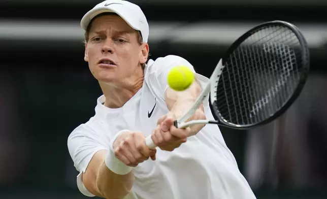 Jannik Sinner of Italy plays a backhand return to Ben Shelton of the United States during their fourth round match at the Wimbledon tennis championships in London, Sunday, July 7, 2024. (AP Photo/Kirsty Wigglesworth)