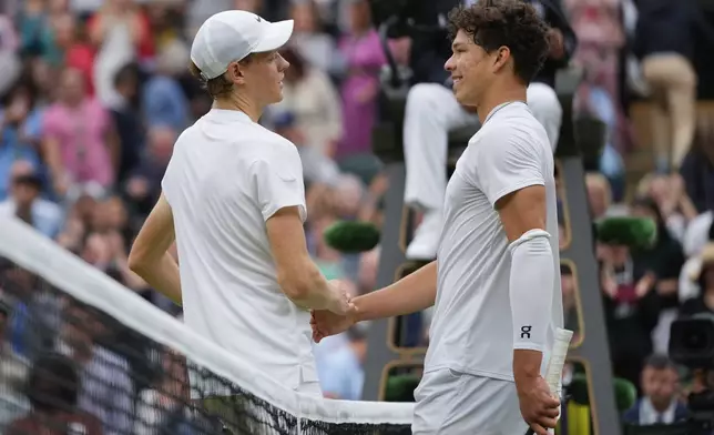 Jannik Sinner, left, of Italy is congratulated by Ben Shelton of the United States following their fourth round match at the Wimbledon tennis championships in London, Sunday, July 7, 2024. (AP Photo/Kirsty Wigglesworth)