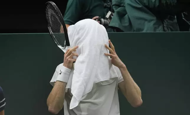 Jannik Sinner of Italy covers his face with a towel during his quarterfinal against Daniil Medvedev of Russia at the Wimbledon tennis championships in London, Tuesday, July 9, 2024. (AP Photo/Alberto Pezzali)
