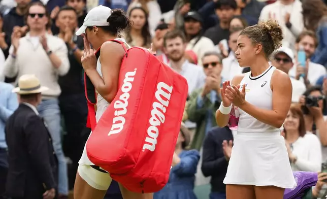 Jasmine Paolini, right, of Italy applauds as Madison Keys of the United States walks from Centre Court after she retired injured during their fourth round match at the Wimbledon tennis championships in London, Sunday, July 7, 2024. (AP Photo/Kirsty Wigglesworth)