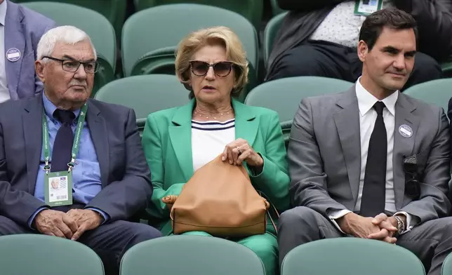 Roger Federer, right, sits with his parents , Robert and Lynette as they watch a third round match between Denis Shapovalov of Canada and Ben Shelton of the United States at the Wimbledon tennis championships in London, Saturday, July 6, 2024. (AP Photo/Alberto Pezzali)