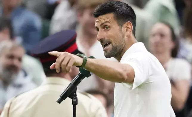 Novak Djokovic of Serbia gestures to the crowd as he is interviewed after defeating Holger Rune of Denmark in their fourth round match at the Wimbledon tennis championships in London, Monday, July 8, 2024.(AP Photo/Kirsty Wigglesworth)