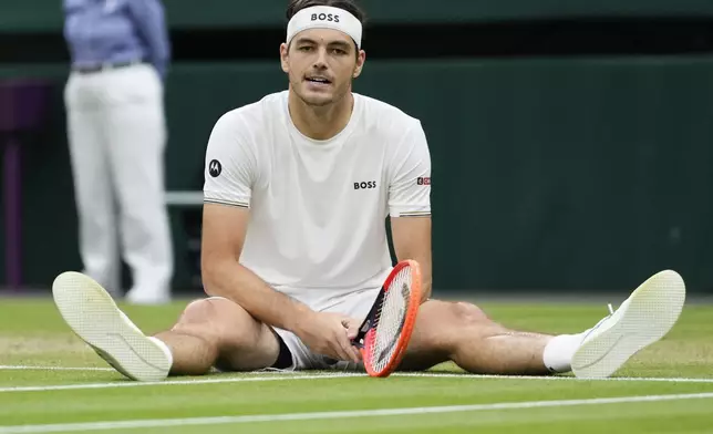 Taylor Fritz of the United States sits on the court after a fall during his fourth round match against Alexander Zverev of Germany at the Wimbledon tennis championships in London, Monday, July 8, 2024. (AP Photo/Kirsty Wigglesworth)