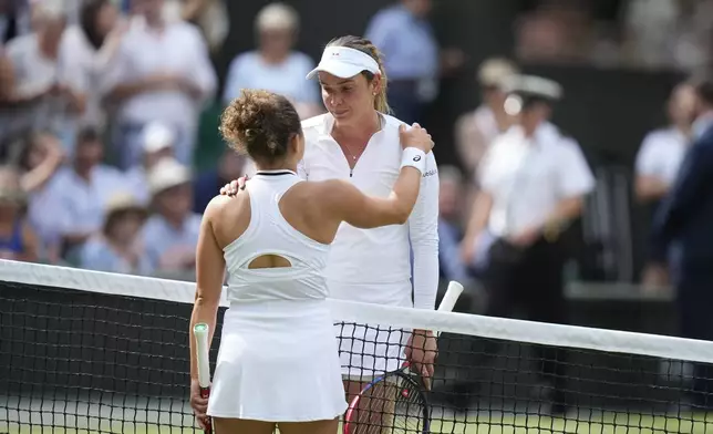 Jasmine Paolini of Italy, left, and Donna Vekic of Croatia get each other at the net after the end of their semifinal match at the Wimbledon tennis championships in London, Thursday, July 11, 2024. Paolini won the match and advances to the final.(AP Photo/Mosa'ab Elshamy)