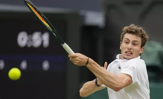 Ugo Humbert of France plays a forehand return to Carlos Alcaraz of Spain during their fourth round match at the Wimbledon tennis championships in London, Sunday, July 7, 2024. (AP Photo/Alberto Pezzali)