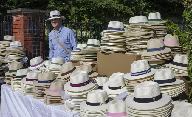 A stall holder prepares to sell hats outside the Wimbledon tennis centre ahead of the first round matches of the Wimbledon tennis championships in London, Monday, July 1, 2024. (AP Photo/Alberto Pezzali)