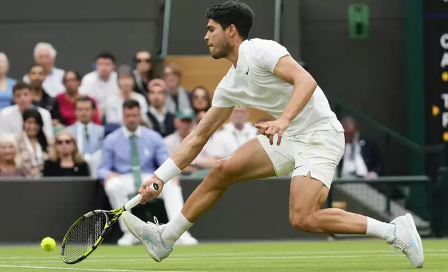 Carlos Alcaraz of Spain plays a forehand return to Tommy Paul of the United States during their quarterfinal match at the Wimbledon tennis championships in London, Tuesday, July 9, 2024. (AP Photo/Kirsty Wigglesworth)