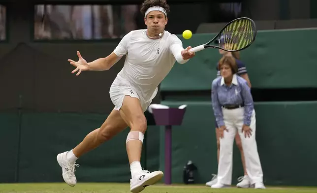 Ben Shelton of the United States plays a forehand return to Denis Shapovalov of Canada during their third round match at the Wimbledon tennis championships in London, Saturday, July 6, 2024. (AP Photo/Alberto Pezzali)