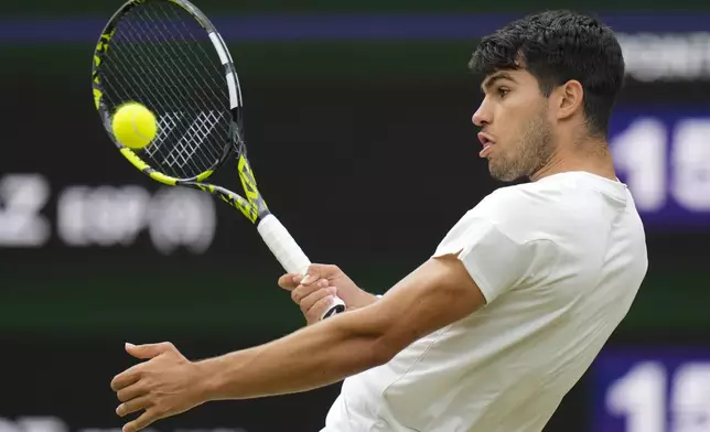 Carlos Alcaraz of Spain plays a forehand return to Ugo Humbert of France during their fourth round match at the Wimbledon tennis championships in London, Sunday, July 7, 2024. (AP Photo/Alberto Pezzali)