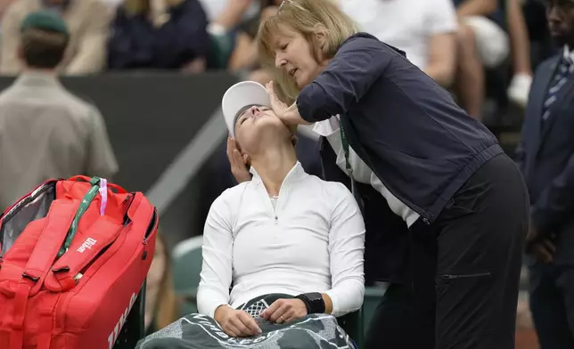 Anna Kalinskaya of Russia receives medical treatment during her fourth round match against Elena Rybakina of Kazakhstan at the Wimbledon tennis championships in London, Monday, July 8, 2024. (AP Photo/Kirsty Wigglesworth)