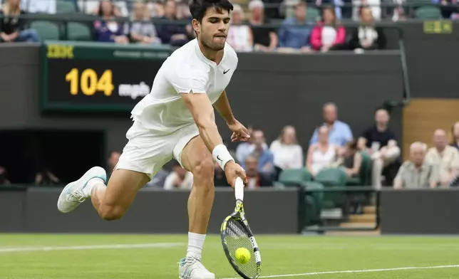 Carlos Alcaraz of Spain plays a forehand return to Tommy Paul of the United States during their quarterfinal match at the Wimbledon tennis championships in London, Tuesday, July 9, 2024. (AP Photo/Kirsty Wigglesworth)