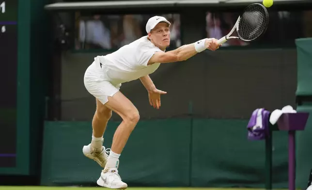 Jannik Sinner of Italy plays a backhand return to Ben Shelton of the United States during their fourth round match at the Wimbledon tennis championships in London, Sunday, July 7, 2024. (AP Photo/Kirsty Wigglesworth)