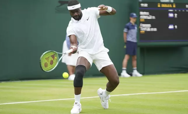 Frances Tiafoe of the United States plays a forehand return to Matteo Arnaldi of Italy during his first round match of the Wimbledon tennis championships in London, Monday, July 1, 2024. (AP Photo/Mosa'ab Elshamy)