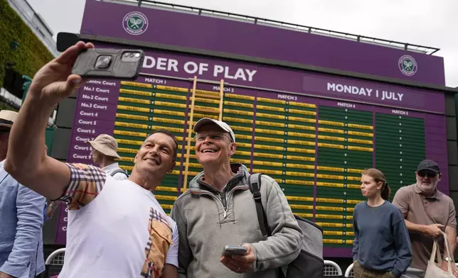 Fans take a selfie ahead of play of the first round matches of the Wimbledon tennis championships in London, Monday, July 1, 2024. (AP Photo/Alberto Pezzali)