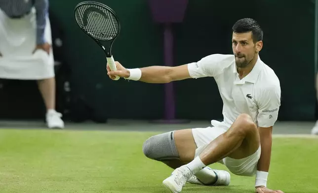 Novak Djokovic of Serbia falls during his fourth round match against Holger Rune of Denmark at the Wimbledon tennis championships in London, Monday, July 8, 2024. (AP Photo/Mosa'ab Elshamy)