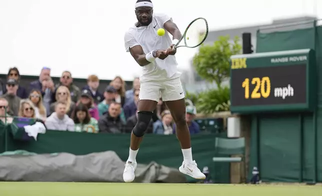 Frances Tiafoe of the United States plays a backhand return to Borna Coric of Croatia during their match on day three at the Wimbledon tennis championships in London, Wednesday, July 3, 2024. (AP Photo/Alberto Pezzali)