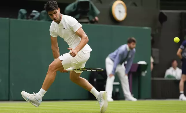 Carlos Alcaraz of Spain plays a shot back between his legs to Ugo Humbert of France during their fourth round match at the Wimbledon tennis championships in London, Sunday, July 7, 2024. (AP Photo/Alberto Pezzali)