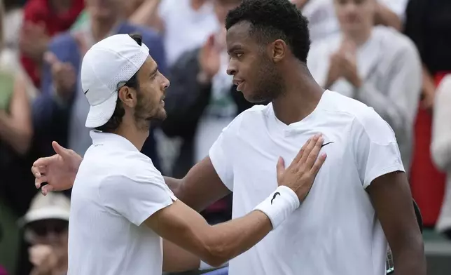 Lorenzo Musetti of Italy is congratulated by Giovanni Mpetshi Perricard, right, of France following their fourth round match at the Wimbledon tennis championships in London, Monday, July 8, 2024. (AP Photo/Mosa'ab Elshamy)