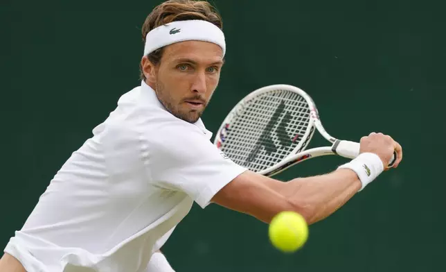 Arthur Rinderknech of France plays a backhand return to Kei Nishikori of Japan during their match on day three at the Wimbledon tennis championships in London, Wednesday, July 3, 2024. (AP Photo/Kirsty Wigglesworth)