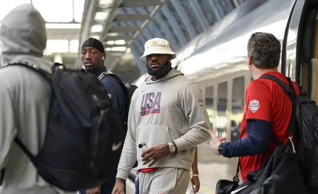 United States' LeBron James, centre, arrives at St Pancras Station with teammates, to take the Eurostar train as they make their way to the Olympic Games in Paris, in London, Wednesday, July 24, 2024.(AP Photo/Alberto Pezzali)