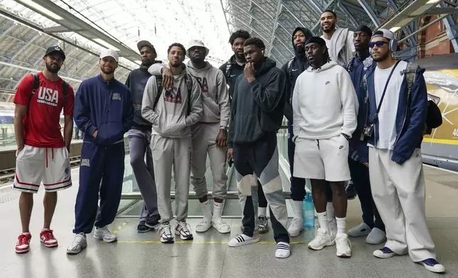 The United States Men's National Basketball Team pose for photographs at St Pancras Station with teammates as they take the Eurostar train as they make their way to the Olympic Games in Paris, in London, Wednesday, July 24, 2024.(AP Photo/Alberto Pezzali)