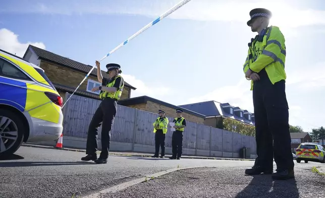 Police officers at the scene in Ashlyn Close where three women were killed in a crossbow attack at their home, on Tuesday, in Bushey, England, Thursday, July 11, 2024. A man suspected of killing the wife and daughters of a BBC radio sports commentator with a crossbow is being treated in a hospital after being found injured in a cemetery. Kyle Clifford is suspected of attacking Carol Hunt, 61, and her daughters Hannah, 28 and Louise, 25. They were found dead at their home in Bushey, a suburban community northwest of London. (Jonathan Brady/PA via AP)