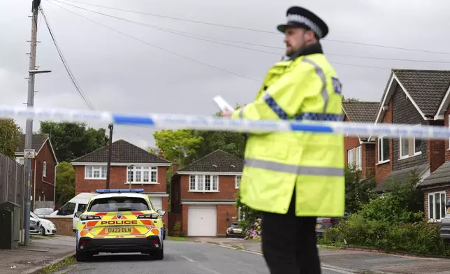 Police at the scene in Ashlyn Close, after an incident on Tuesday evening, in Bushey, Hertfordshire, England, Wednesday, July 10, 2024. British police were hunting for a man believed to be armed with a crossbow on Wednesday after three women were killed in a house near London. The BBC said the women killed were the family of its main radio racing commentator John Hunt. (James Manning/PA via AP)