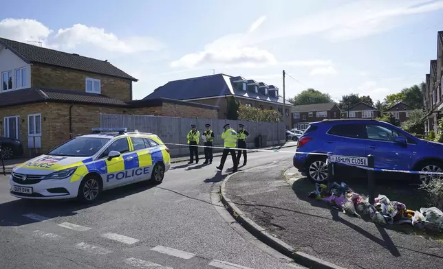 Police officers at the scene in Ashlyn Close where three women were killed in a crossbow attack at their home, on Tuesday, in Bushey, England, Thursday, July 11, 2024. A man suspected of killing the wife and daughters of a BBC radio sports commentator with a crossbow is being treated in a hospital after being found injured in a cemetery. Kyle Clifford is suspected of attacking Carol Hunt, 61, and her daughters Hannah, 28 and Louise, 25. They were found dead at their home in Bushey, a suburban community northwest of London. (Jonathan Brady/PA via AP)