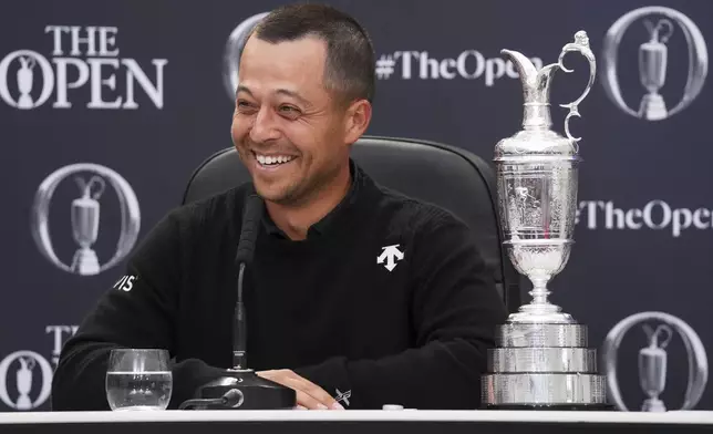 Xander Schauffele of the United States reacts as he sits with the Claret Jug trophy at a press conference after winning the British Open Golf Championships at Royal Troon golf club in Troon, Scotland, Sunday, July 21, 2024. (AP Photo/Jon Super)