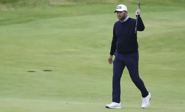 Daniel Brown of England gestures to the spectators as he walks to the 18th green during his final round of the British Open Golf Championships at Royal Troon golf club in Troon, Scotland, Sunday, July 21, 2024. (AP Photo/Scott Heppell)