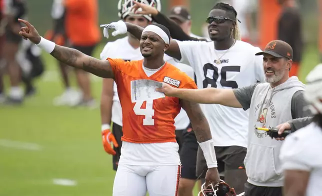 Cleveland Browns quarterback Deshaun Watson (4), tight end David Njoku (85) and head coach Kevin Stefanski, right, gesture during an NFL football training camp practice in White Sulphur Springs, W.Va., Thursday, July 25, 2024. (AP Photo/Sue Ogrocki)