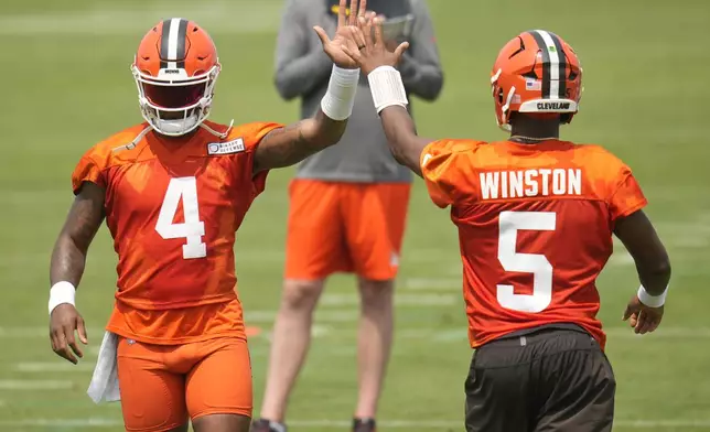 Cleveland Browns quarterbacks Deshaun Watson (4) and Jameis Winston (5) high-five during an NFL football training camp practice Saturday, July 27, 2024, in White Sulphur Springs, W.Va. (AP Photo/Sue Ogrocki)