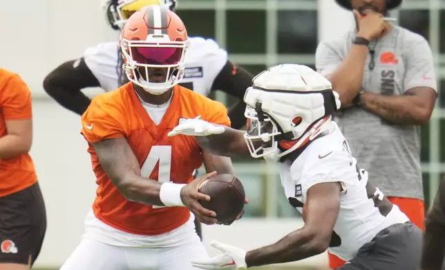 Cleveland Browns quarterback Deshaun Watson (4) hands off to running back Pierre Strong Jr., right, during an NFL football training camp practice in White Sulphur Springs, West Virginia, Thursday, July 25, 2024. (AP Photo/Sue Ogrocki)